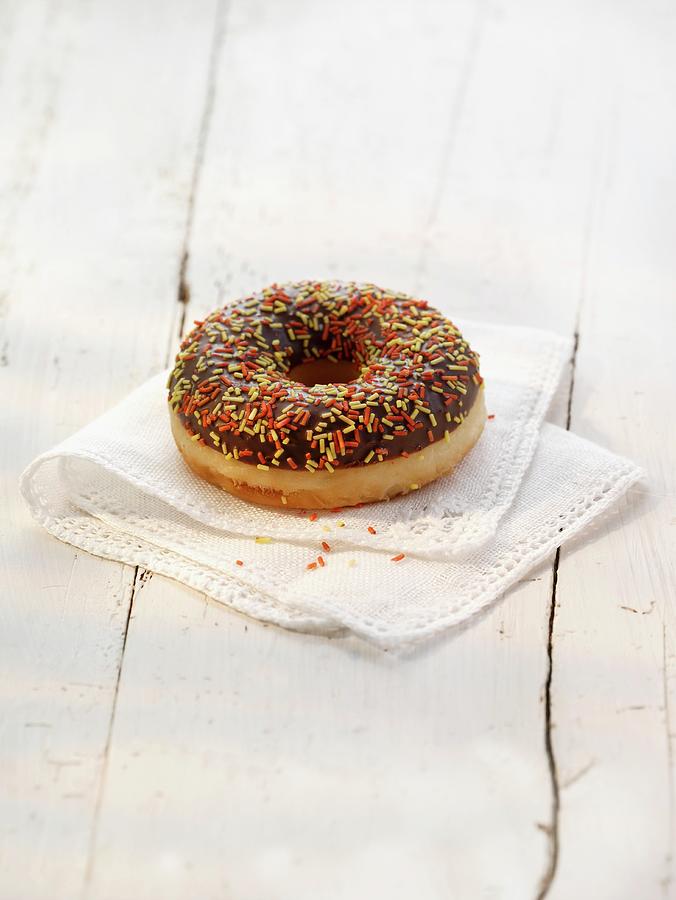 A Doughnut With Chocolate Glaze And Colourful Sugar Sprinkles Photograph by Foodfoto Kln