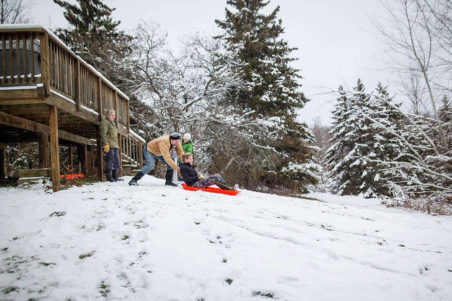 A Family Sled Together On A Hill In Their Back Yard Photograph by Cavan ...