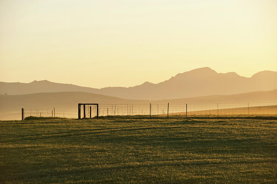 A Farm Fence Is Silhouetted Against The Photograph by Rodger Shagam
