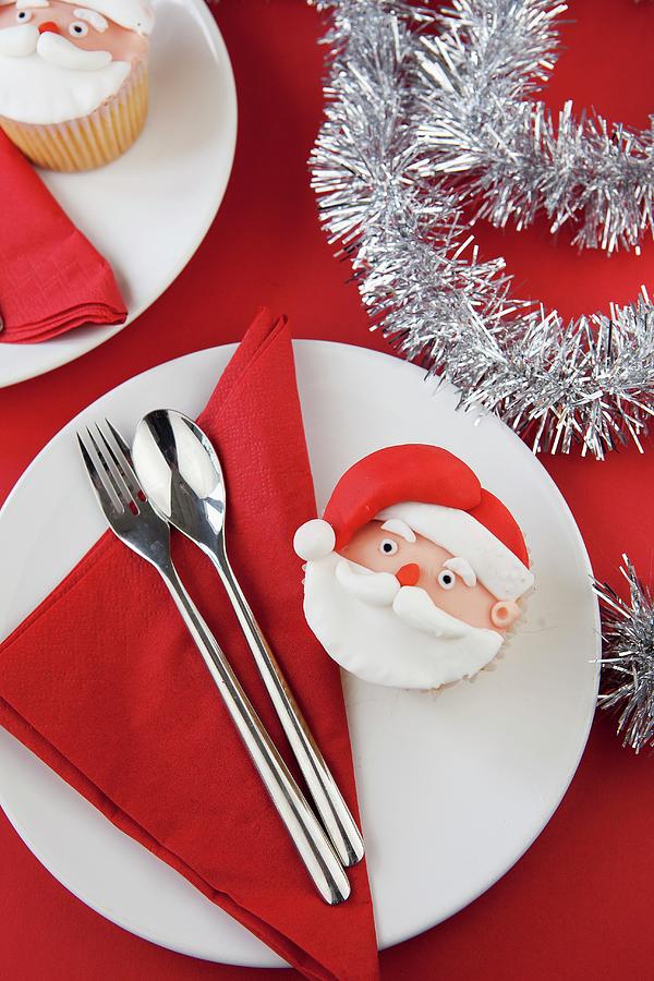 A Father Christmas Cupcake On A Plate With A Napkin And Cutlery Photograph by Zara Daly