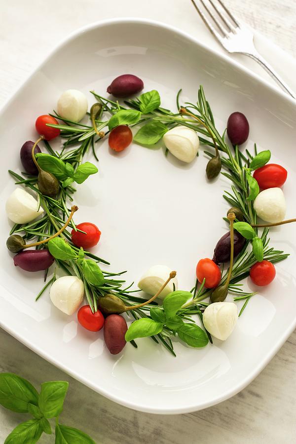 A Festive Wreath Made From Basil, Rosemary, Capers, Mozzarella, Olives And Cherry Tomatoes Photograph by Sandra Krimshandl-tauscher