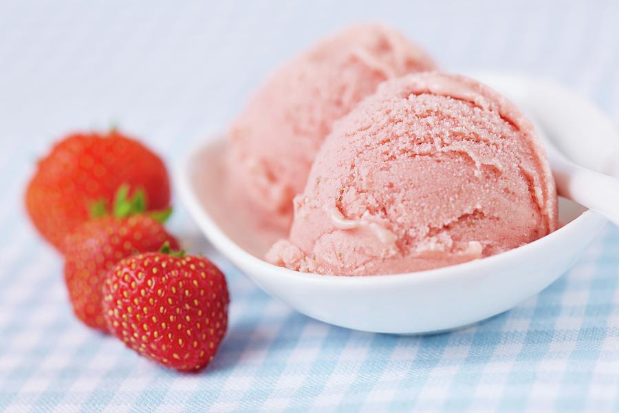 A Few Fresh Strawberries Alongside Two Scoops Of Home-made Strawberry Ice Cream Photograph by Robert Kneschke
