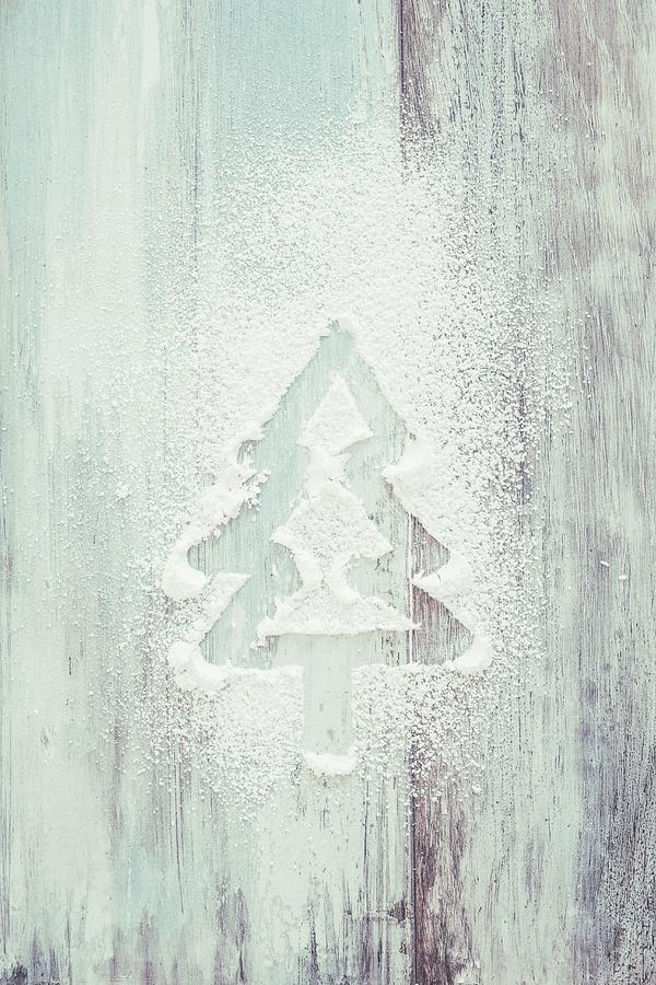 A Fir Tree Drawn In Powdered Sugar On A White Wooden Background Photograph by Jan Wischnewski