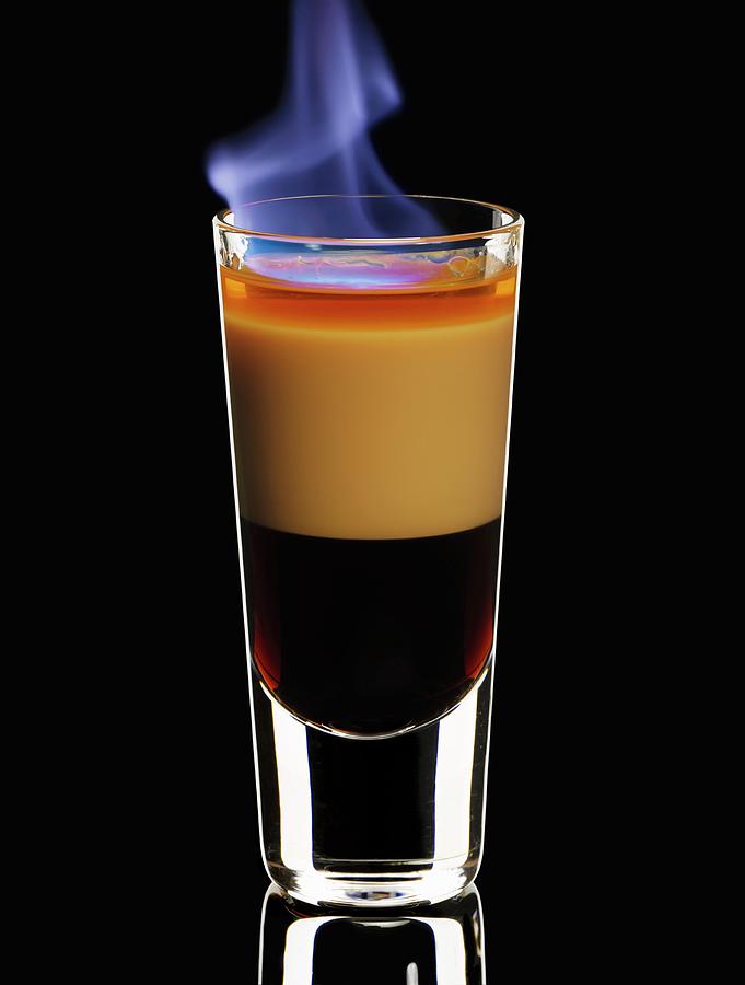 A Flambed B-52 Cocktail In A Glass On A Black Background Photograph by Hermann Drre