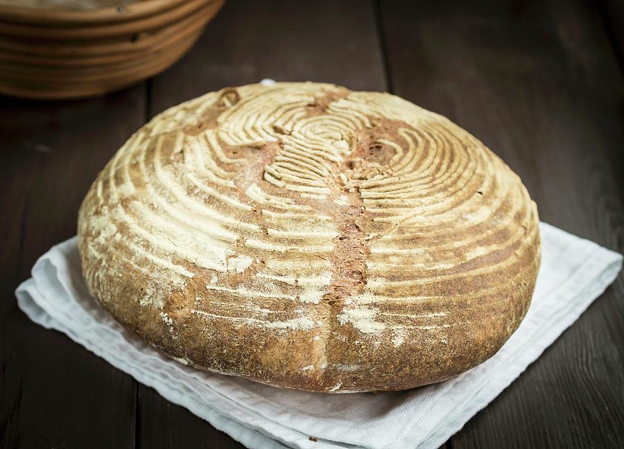 A Freshly Baked Homemade Loaf Of Wheat Sourdough Bread On A Wooden Table Photograph by Magdalena Paluchowska