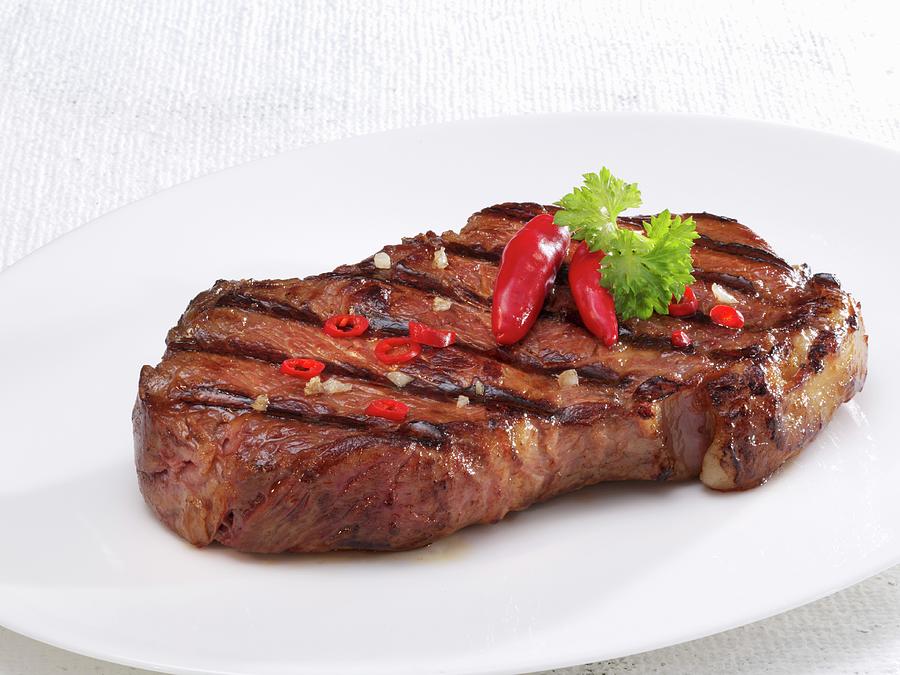 A Fried Beef Steak With Chilli Peppers Photograph by Karl Newedel