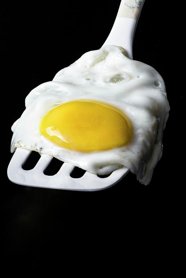 A Fried Egg On A White Spatula On A Black Background Photograph by Magdalena Hendey