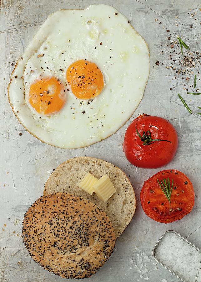 A Fried Egg With Tomatoes And A Poppyseed Roll With Butter Photograph by Jane Saunders