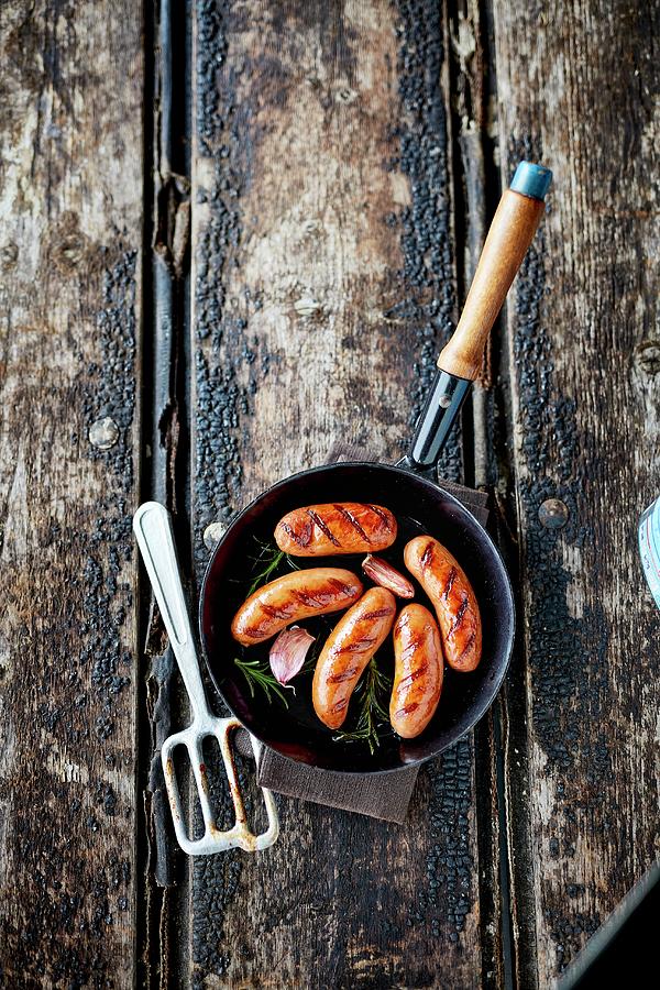 A Frying Pan With Sausages, Garlic And Rosemary Photograph by Rafael Pranschke