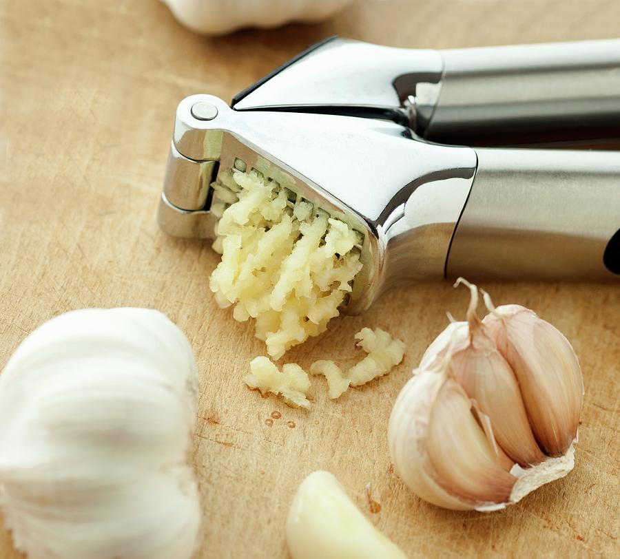 A Garlic Crusher And Garlic Photograph by William Boch