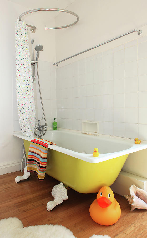 A Giant Rubber Duck In Front Of A Yellow Bathtub With A Shower And A Shower Curtain Photograph by Steven Morris