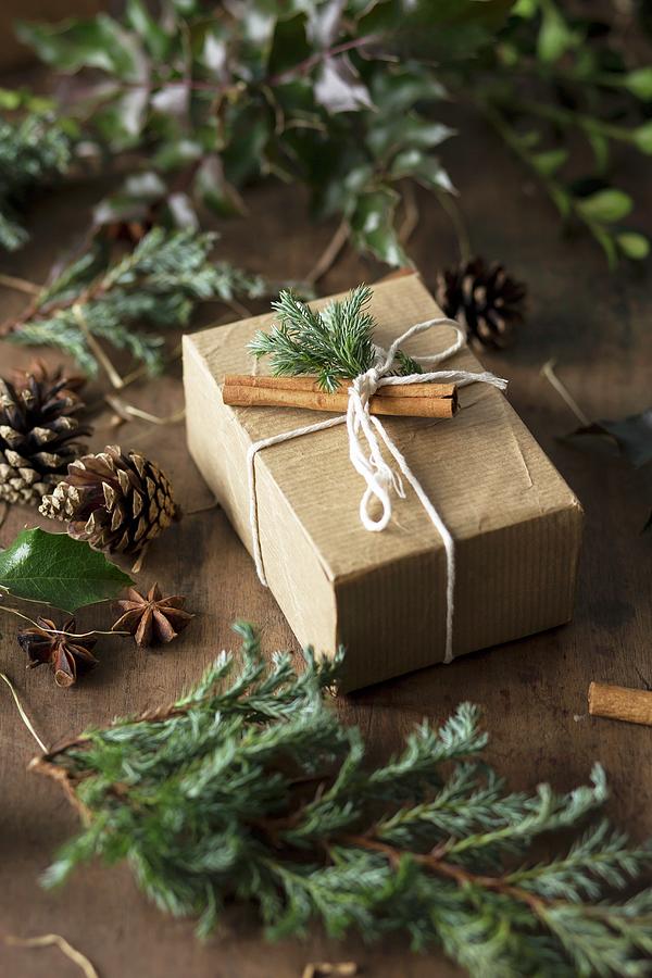 A Gift Decorated With Conifer Sprigs And Cinnamon Sticks Photograph by Malgorzata Laniak