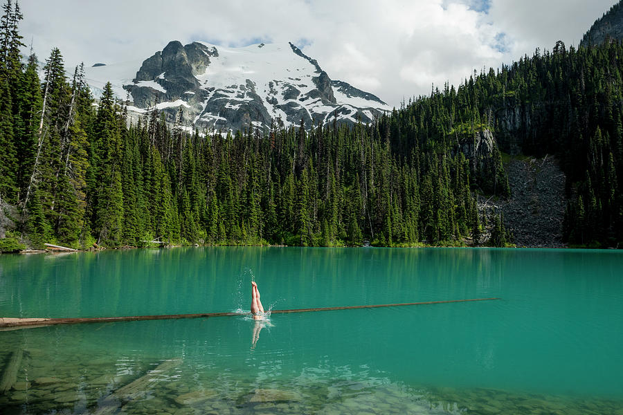 A Girl Does A Well Executed Dive Into The Blue Waters Of Joffre Lakes Photograph by Cavan Images