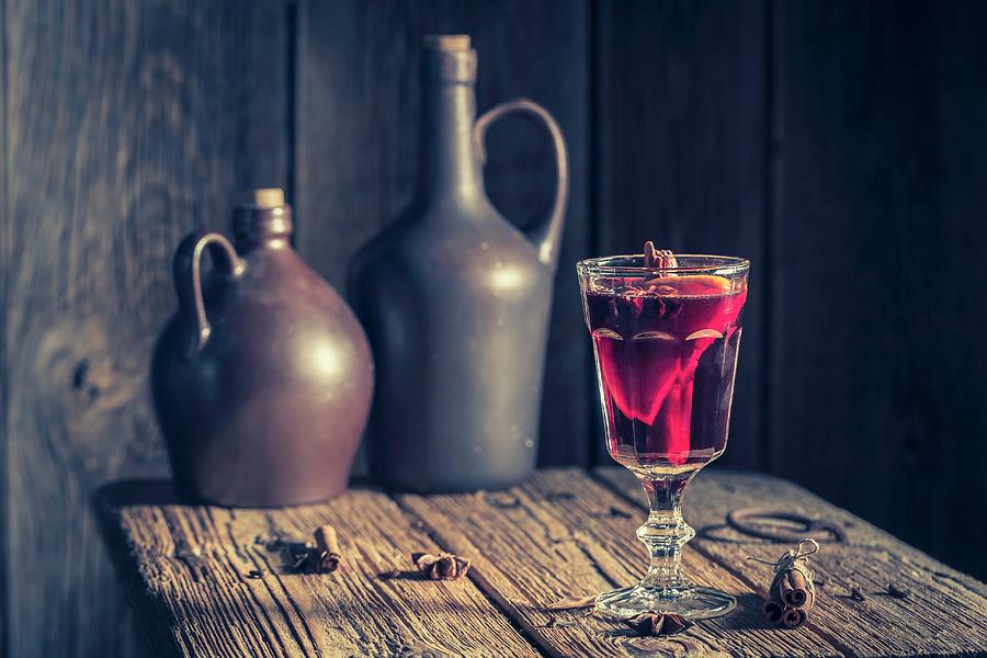 A Glas Of Mulled Wine With Spices On A Rustic Table For Christmas Photograph by Shaiith