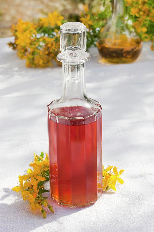 A Glass Bottle Of Home-made Red Oil st Johns Wort Flowers In Olive Oil Photograph by Sabine Lscher