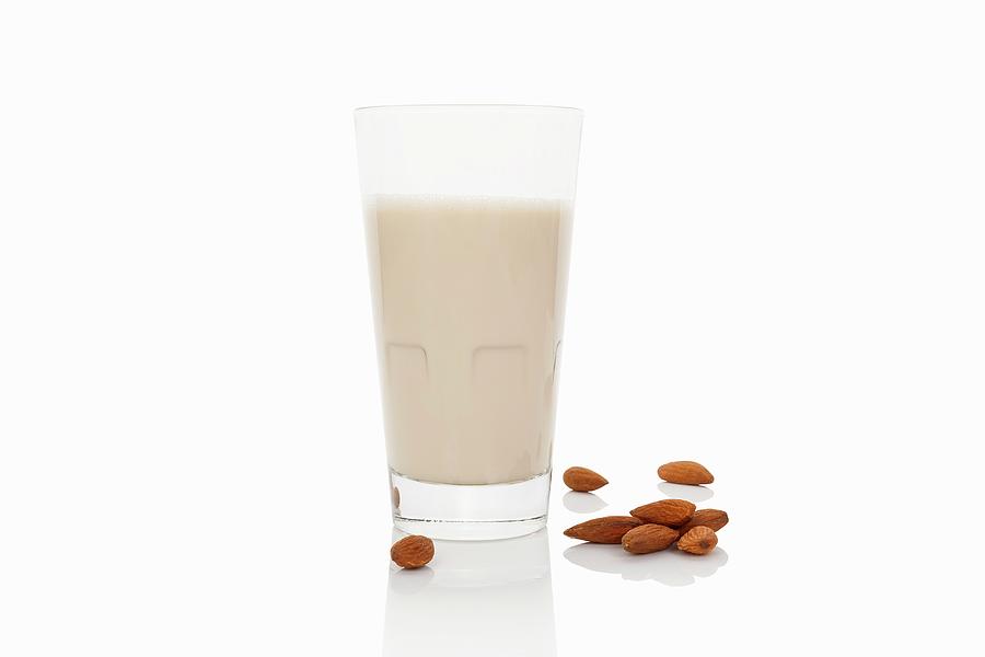 A Glass Of Almond Milk On A White Surface Photograph by Martina Kovacova