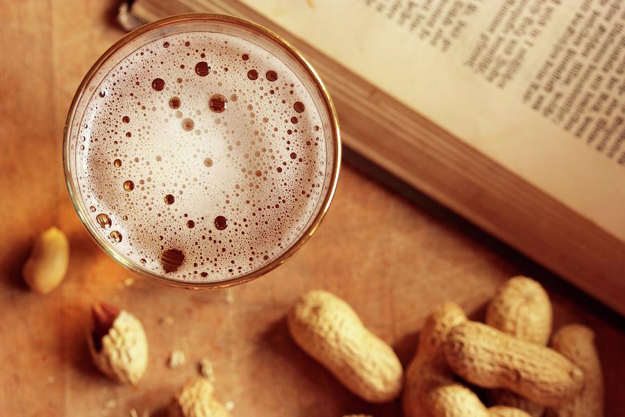 A Glass Of Beer And Peanuts Next To An Open Book seen From Above Photograph by Vivi Dangelo