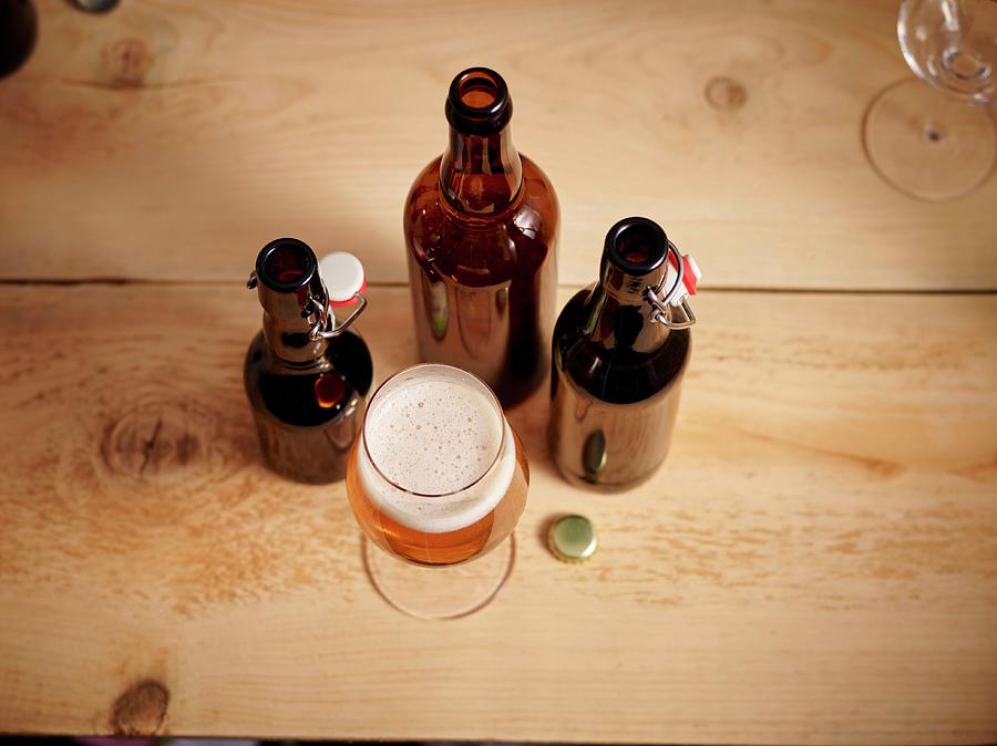 A Glass Of Beer And Three Opened Beer Bottles Photograph by Christopher Mick