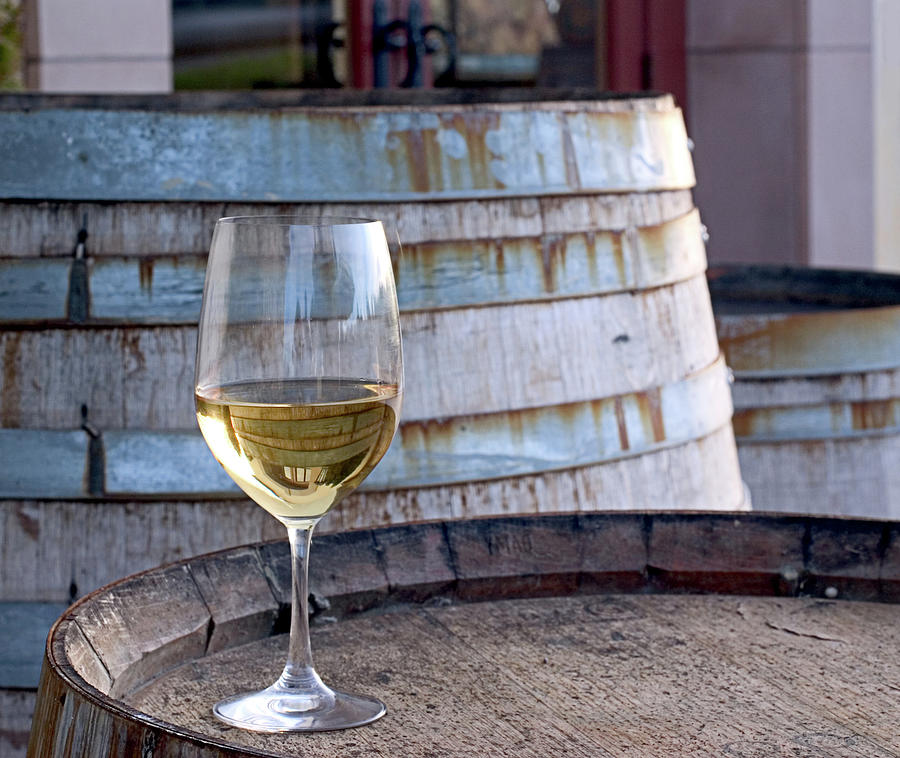 A Glass Of Chardonnay Sitting On A Photograph by Swalls