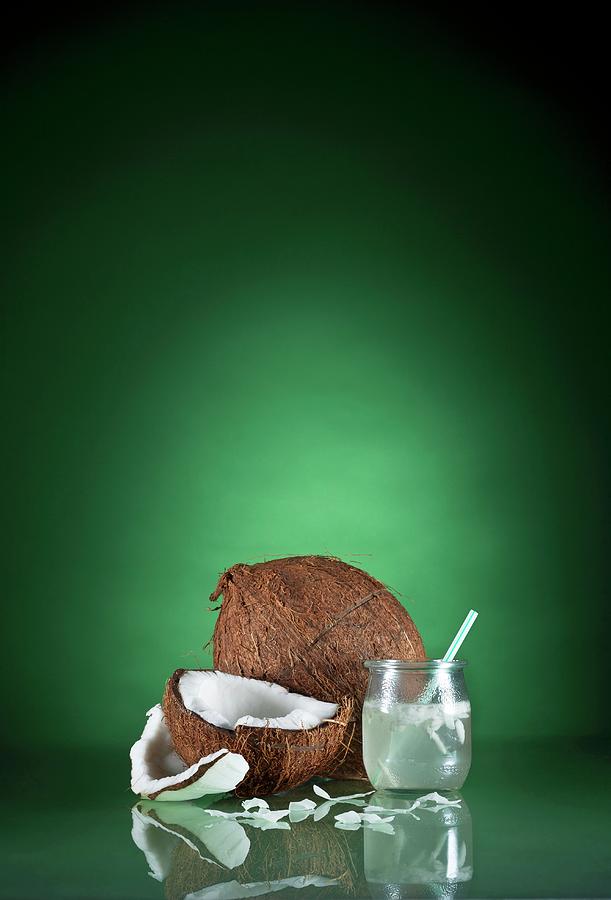 A Glass Of Coconut Water With A Straw And Fresh Coconut Photograph by Richard Fleischman