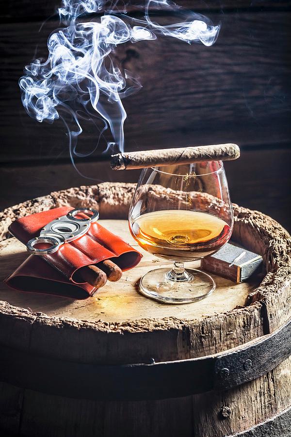 A Glass Of Cognac And Cigars On An Old Wooden Barrel Photograph by Shaiith