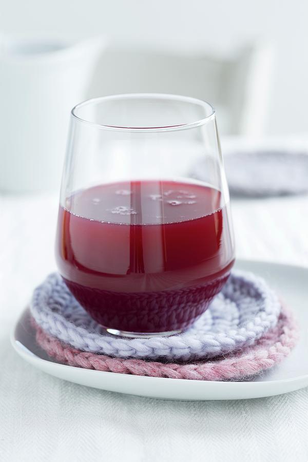A Glass Of Freshly Pressed Pomegranate Juice On Homemade, Crocheted Coasters Photograph by Sabine Lscher