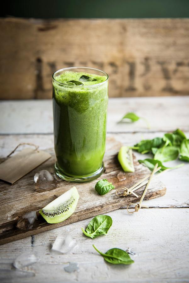 A Glass Of Kiwi And Spinach Smoothie With Fresh Spinach Leaves And Slices Of Kiwi Photograph by Magdalena Hendey