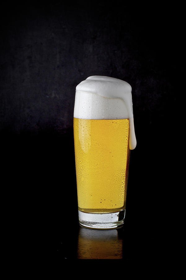 A Glass Of Lager Against A Black Background Photograph by Sabine Mader
