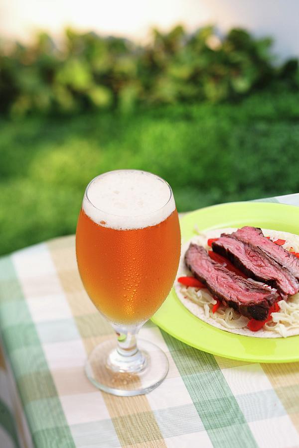 A Glass Of Largo On A Garden Table With A Plate Of Beef On A Cabbage Salad Photograph by Perry Jackson