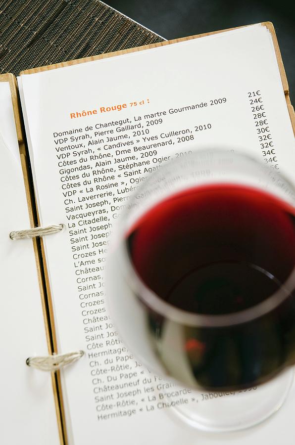 A Glass Of Red Wine On A Wine List Photograph by Anthony Lanneretonne