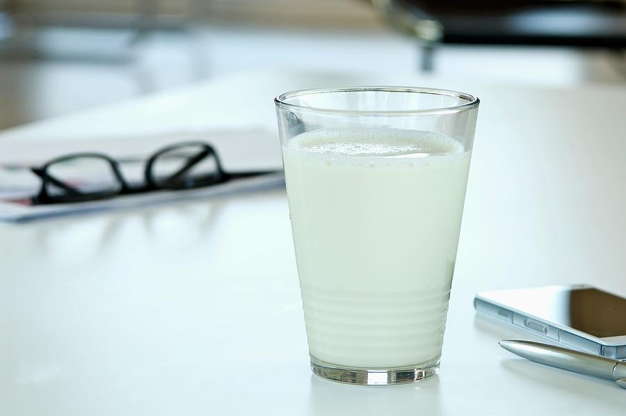 A Glass Of Soya Milk On A Desk In An Office Photograph by Achim Sass