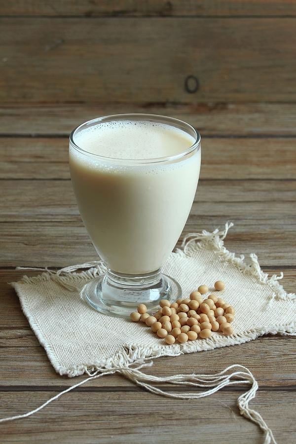 A Glass Of Soya Milk With Soya Beans Next To It Photograph by Milly Kay