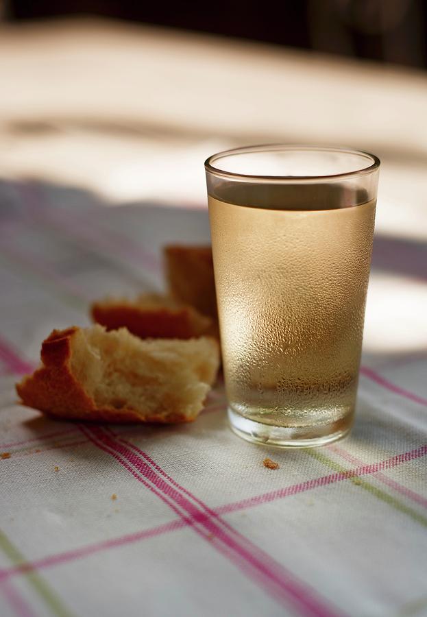 A Glass Of White Wine And Bread On A Sunny Table Photograph by Roger Stowell
