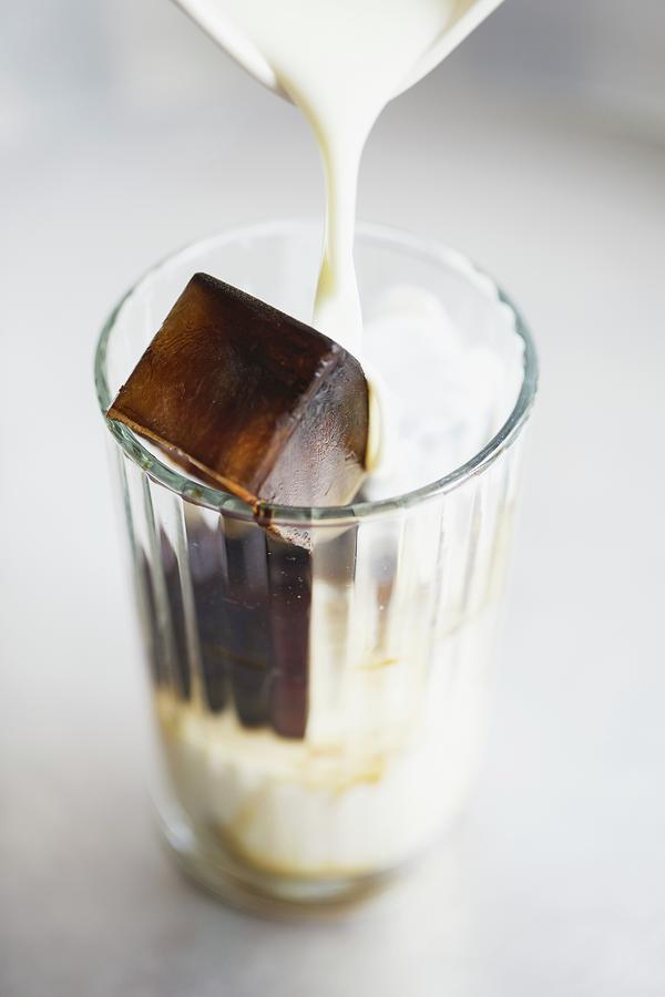 A Glass With An Espresso Ice Cube And Milk Photograph by Tina Engel