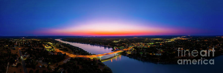 Sunset Photograph - A gorgeous sunset falls on the bridge over Lake Marble Falls by Dan Herron