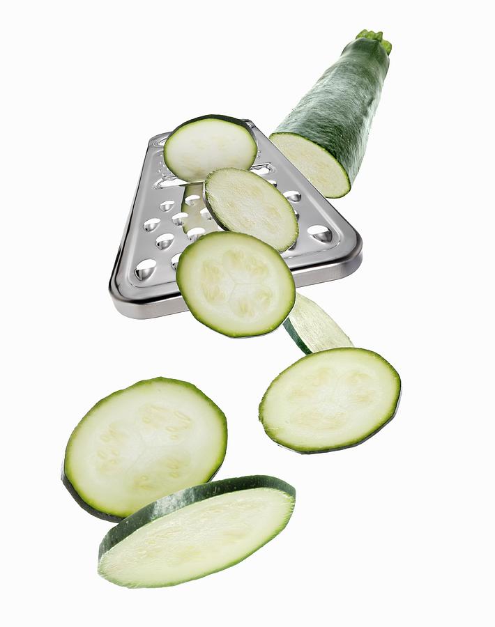 A Grater With A Courgette And Courgette Slices Photograph by Krger & Gross