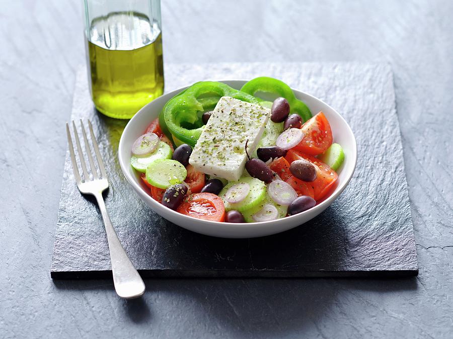 A Greek Salad Next To A Bottle Of Olive Oil Photograph by Rua Castilho