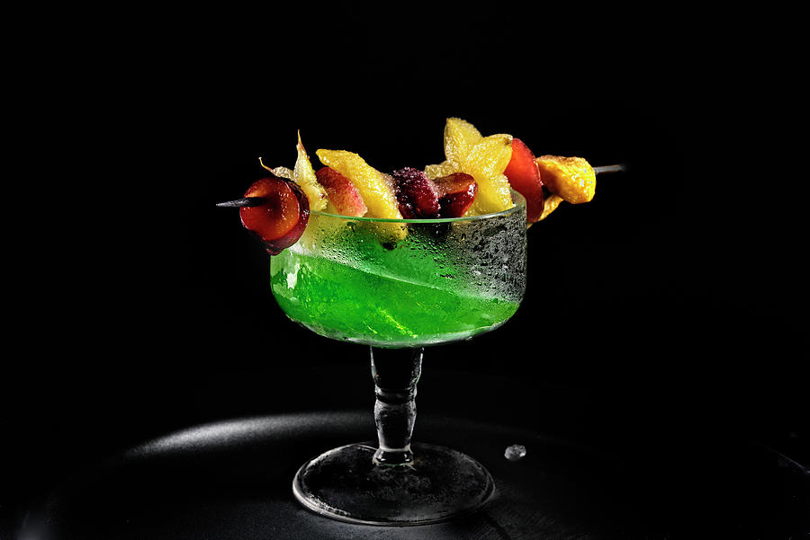 A Green Drink With An Exotic Fruit Skewer Photograph by Kaktusfactory