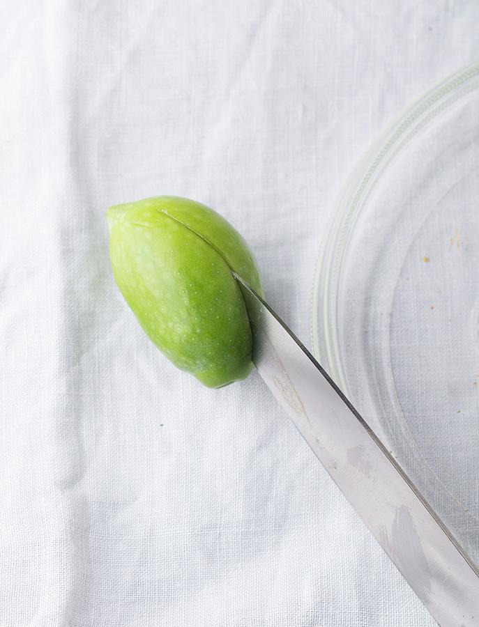 A Green Olive Being Halved With A Knife close-up Photograph by Manuela Rther