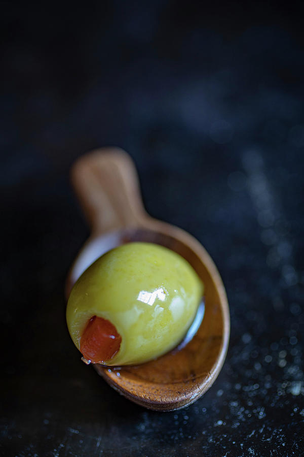 A Green Olive On A Wooden Spoon Photograph by Eising Studio