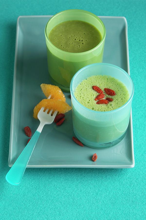 A Green Smoothie Made With Mandarin, And A Banana And Pineapple Smoothie With Goji Berries Photograph by Joerg Lehmann