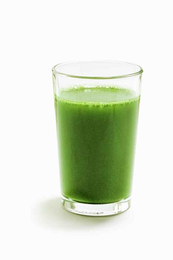 A Green Wheatgrass Smoothie On A White Surface Photograph by Petr Gross