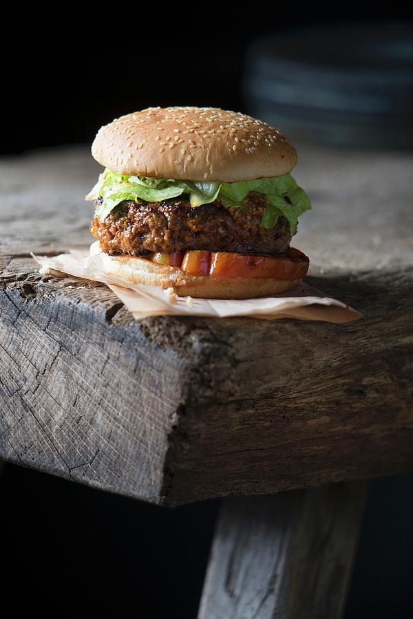 A Grilled Hamburger On A Wooden Table Photograph by Jalag / Joerg Lehmann