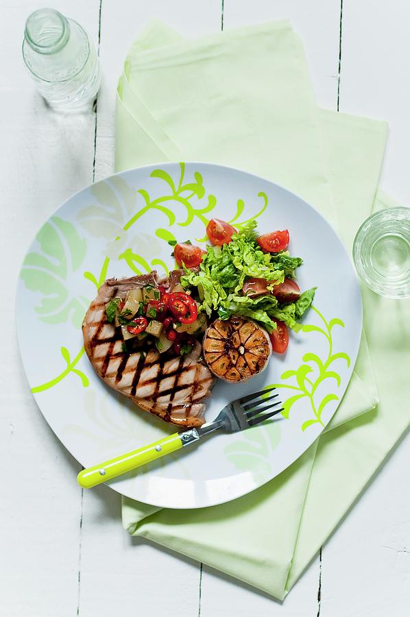 A Grilled Pork Chop With Salad, Garlic And Pineapple Salsa Photograph by Tomasz Jakusz