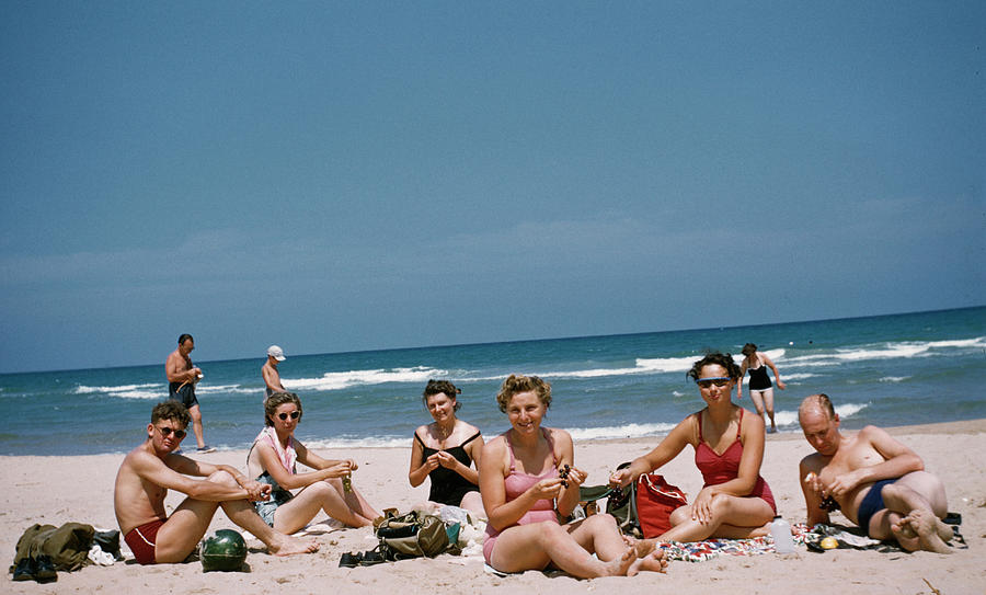 A Group Of Friends Sunbathe On Beach Photograph by Frances M. Ginter