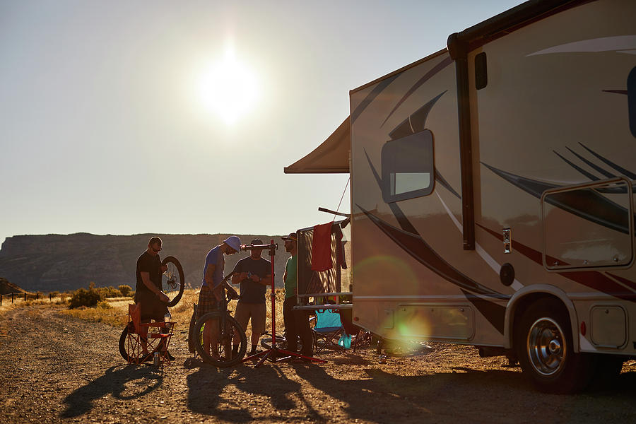 Mountain Photograph - A Group Of Guys Working On Mountain Bikes At The Rear Of An Rv. by Cavan Images