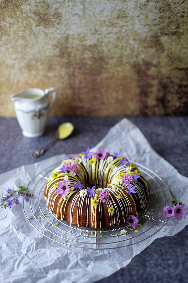 A Guglhupf With Yellow And White Icing And Edible Flowers Photograph by Marions Kaffeeklatsch