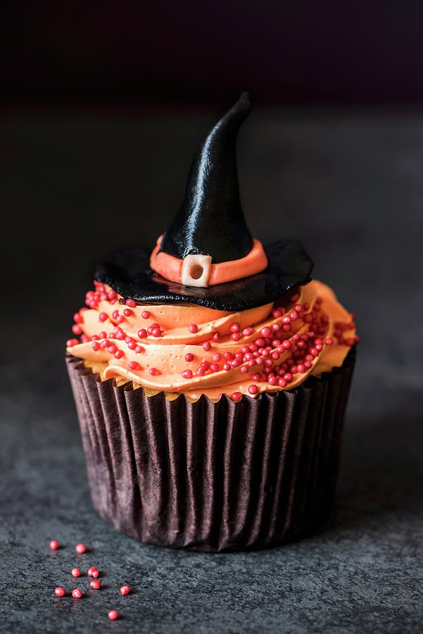 Halloween Photograph - A Halloween Cupcake With Orange Buttercream An A Witches Hat by Magdalena Hendey