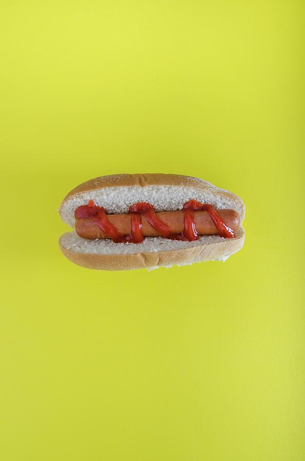 A Hot Dog Against A Yellow Background Photograph by Nick Sida