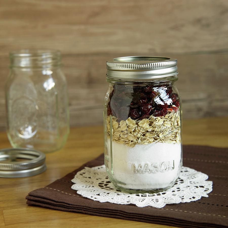 A Jar Containing Dry Ingredients For Making Oatmeal And Cranberry Biscuits Photograph by Dinner, Allison